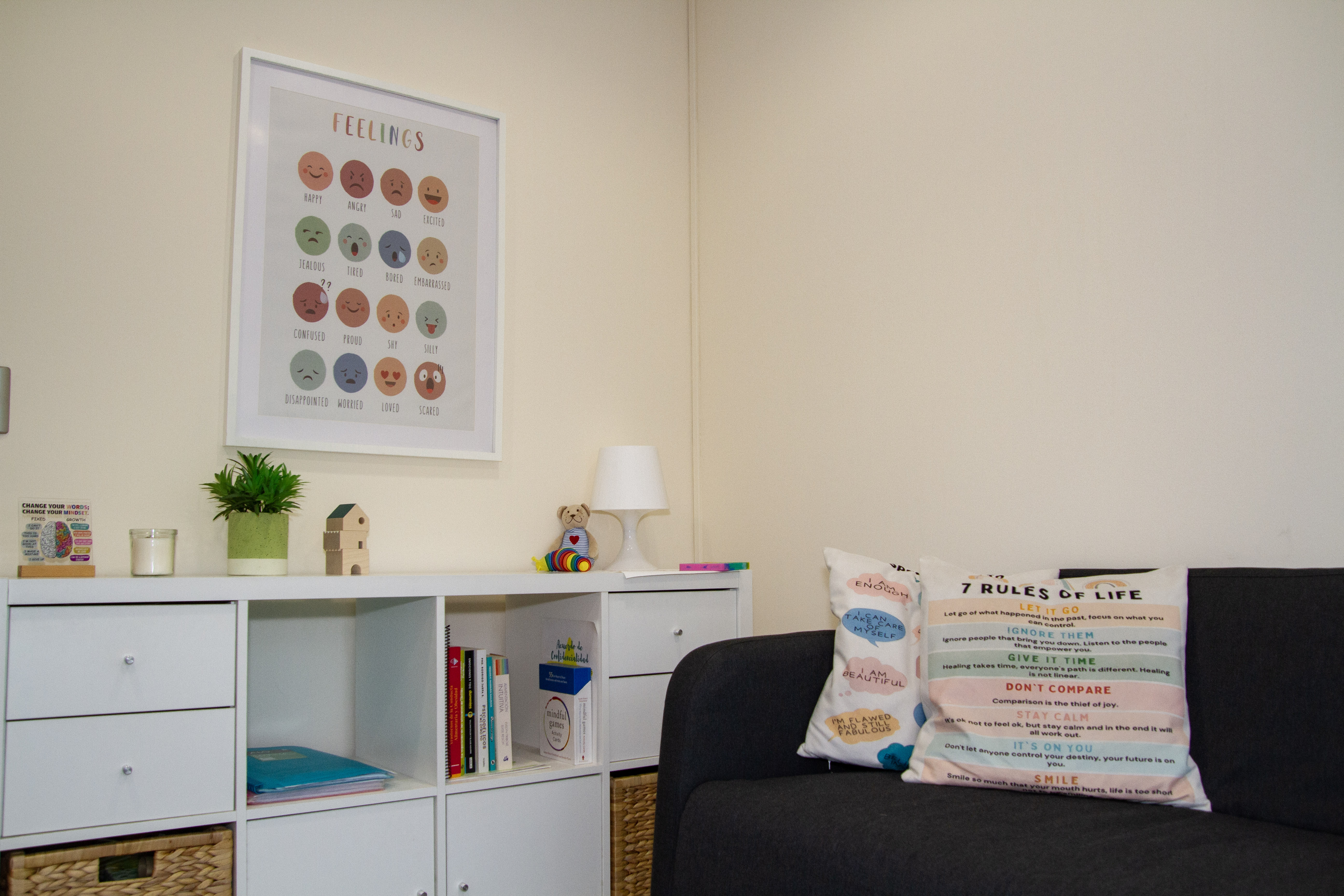 Sala de psicología en Umma: póster de emociones, libros, sofá y espacio para niños